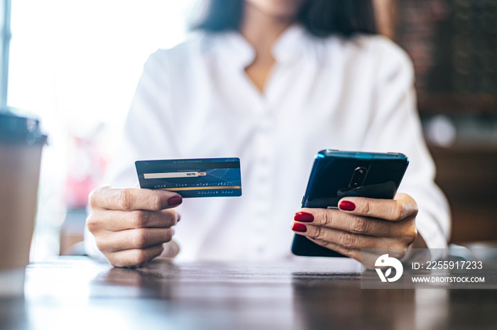 Pay for goods by credit card through a smartphone in a coffee shop.