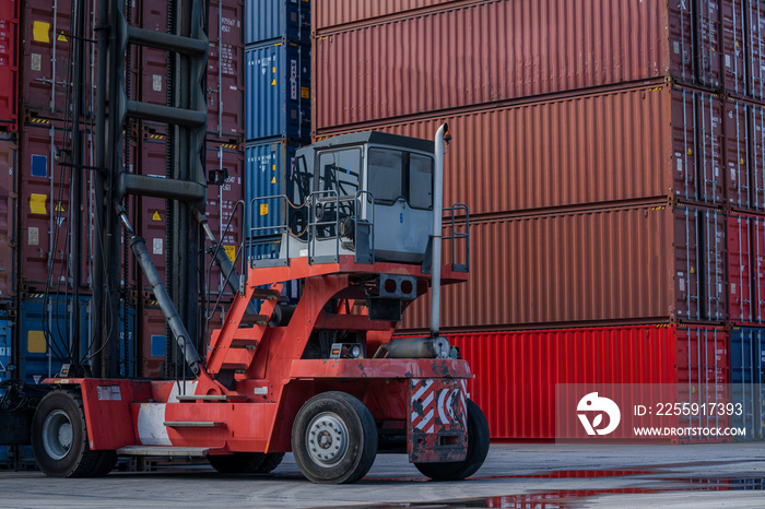 Crane lifting up container and unloading cargo into the import-export zone in yard.