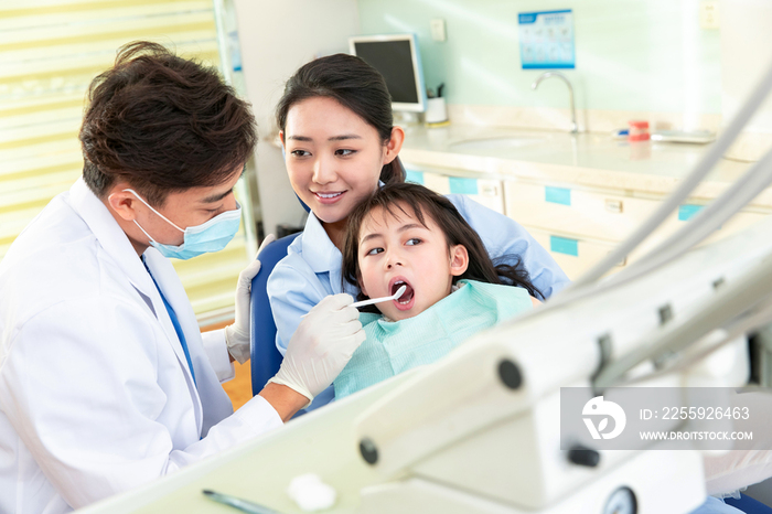 牙科医生给小女孩检查牙齿
