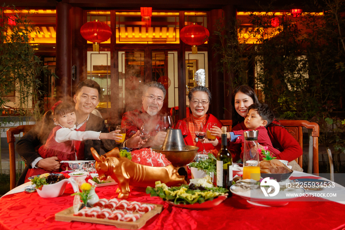 东方家庭在中式庭院内干杯庆祝新年