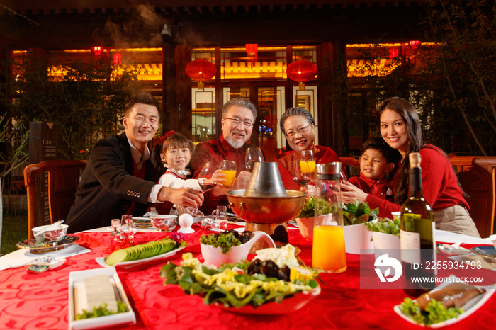 东方家庭在中式庭院内干杯庆祝新年