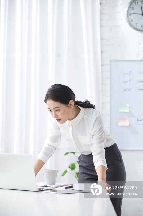 青年商务女人使用笔记本电脑办公