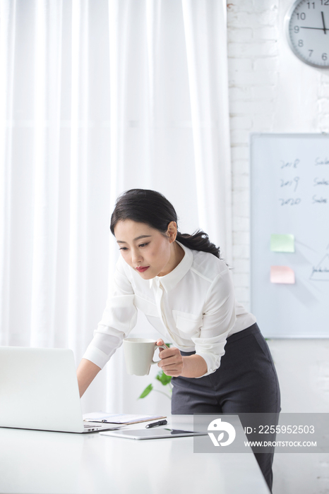 青年商务女人使用笔记本电脑办公