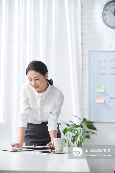 青年商务女人使用笔记本电脑办公