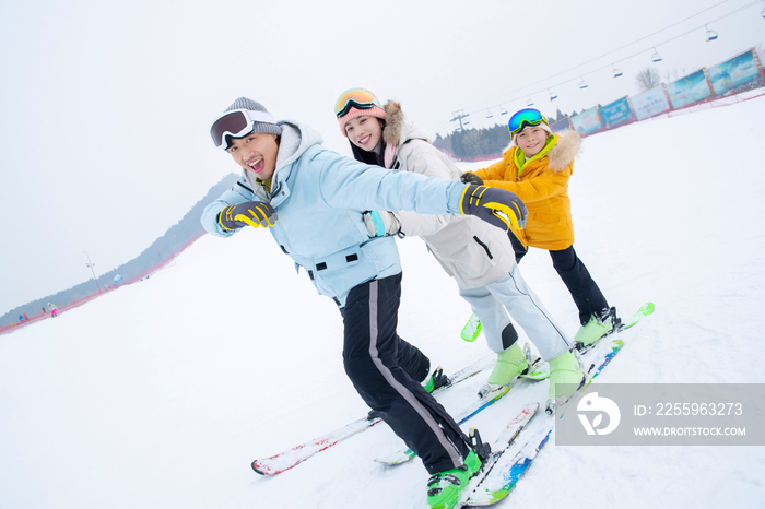 滑雪场上踩着滑雪板排队行走的一家三口