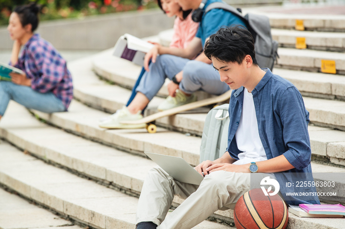 快乐的大学生坐在台阶上学习