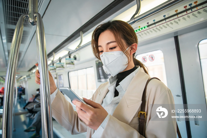 青年女人在地铁上看手机