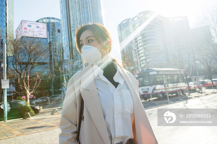 青年女人戴口罩在户外行走