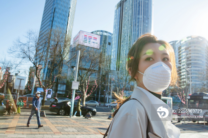 青年女人戴口罩在户外行走