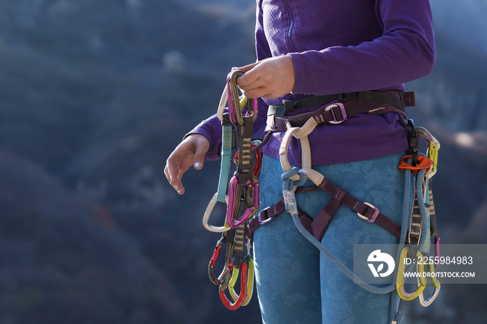 青年女性登山者调整安全设备