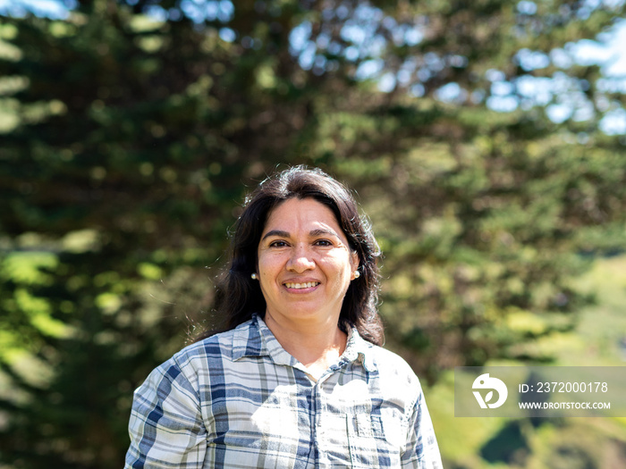 portrait of middle-aged latina woman on sunny day in nature