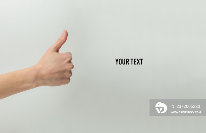 Female hand shows thumb up gesture on a white background with space for your text