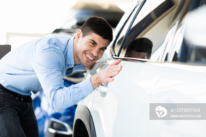 Man Touching His New Auto In Dealership Showroom