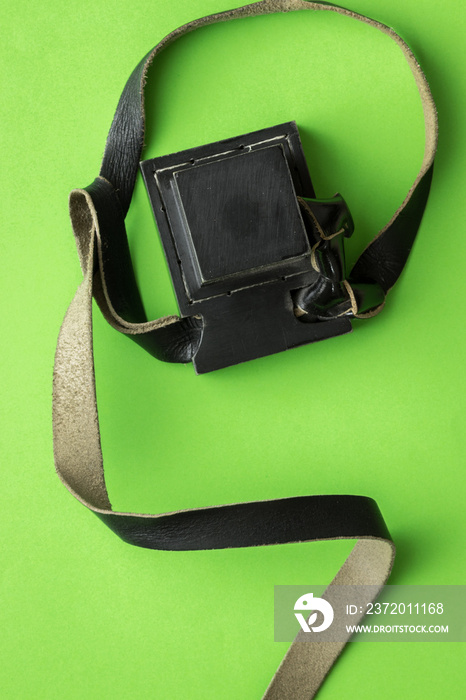 Tefillin made of black cowhide, on a green background