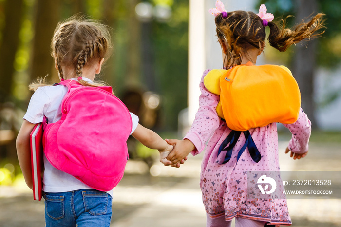 Two happy cheerful girls running to school