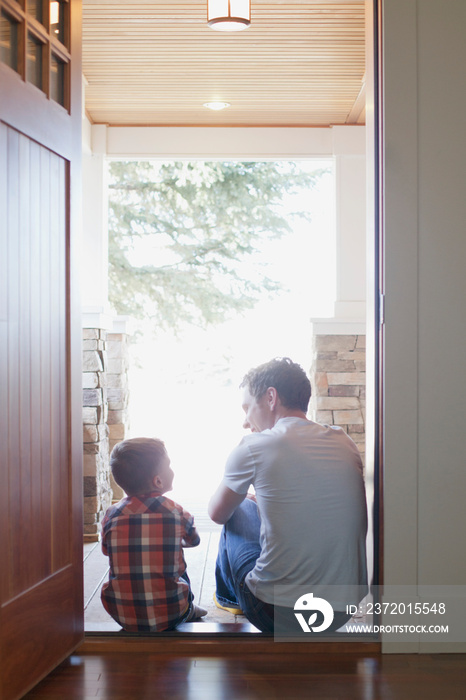 father and son sitting in doorway