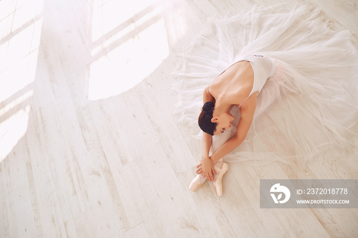 Young ballerina posing on the floor