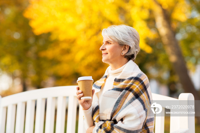 old age, retirement and people concept - portrait of senior woman drinking takeaway coffee at autumn