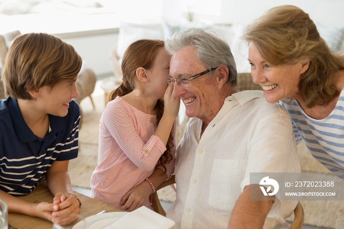 Granddaughter sharing secret with grandfather