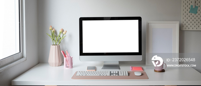 Front view of computer and office supplies at female workplace.