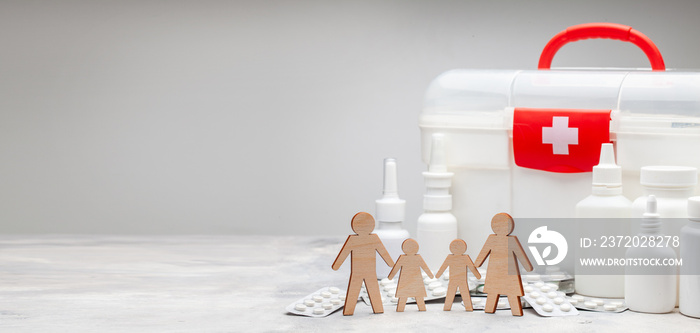 Family medicine. Family with children on the background of a first-aid kit and medicines with pills