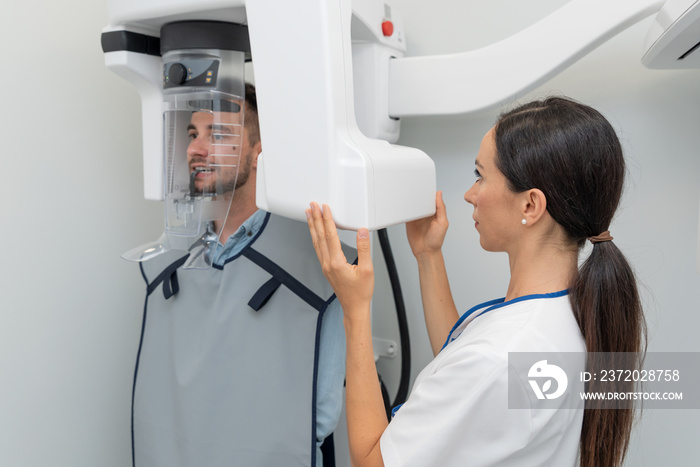 Patient standing in x-ray machine at dental clinic