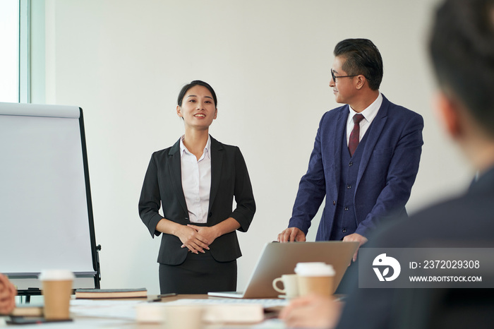 young asian new employee introduced to team by boss during staff meeting in office