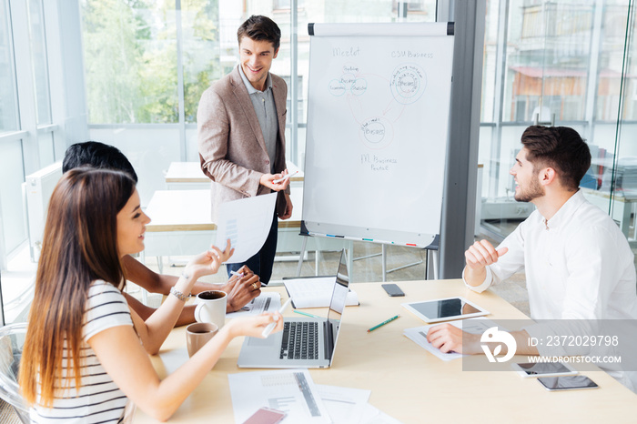 Happy businessman making presentation for business people in office