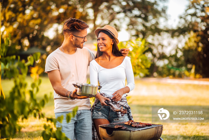 Young couple making barbecue, copy space. Summer vacation concept