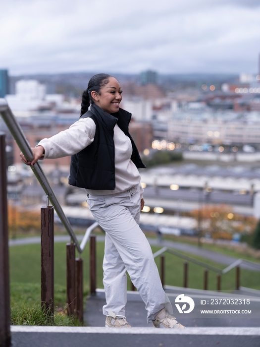 Smiling teenage girl standing on steps in city