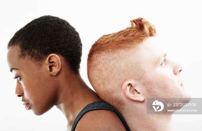 Studio portrait of young couple back to back