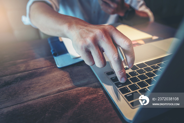 Close up of businessman finger pushing enter button on laptop computer, decision for online business