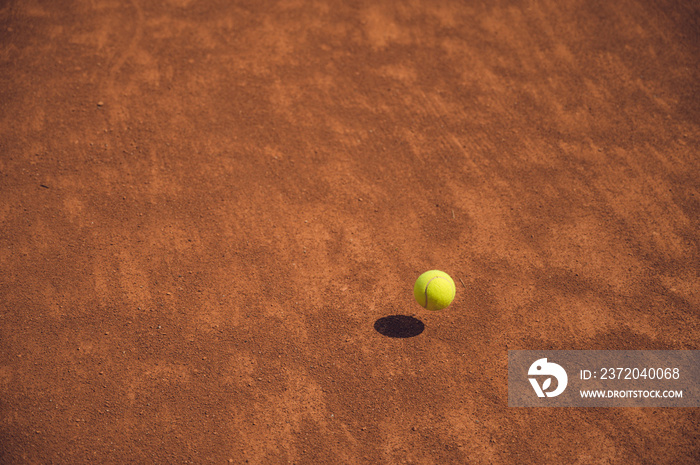 黄色网球在红土网球场下摆动。比赛过程。运动。生活方式。