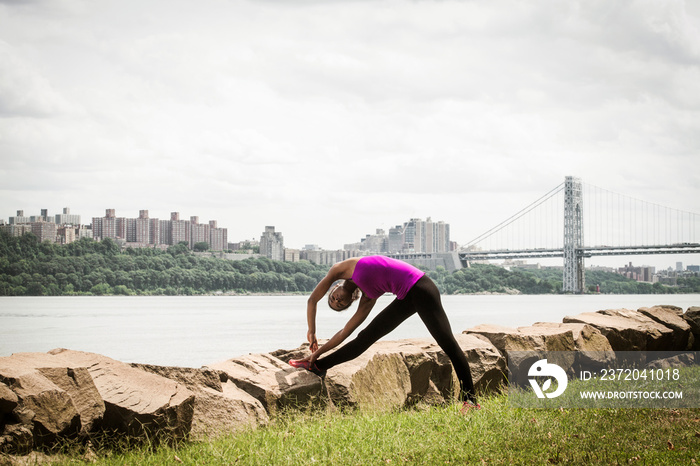 Side-view of young woman stretching