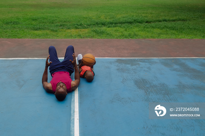 Boy holding basketball at warm up with father