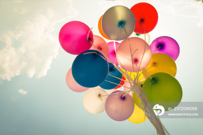 Colorful festive balloons over blue sky with a retro vintage instagram filter effect.