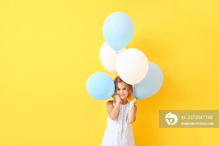 Little girl with balloons on color background