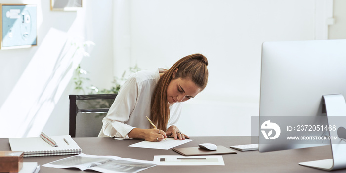 年轻的女建筑师在办公室里绘制设计草图