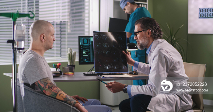 Oncologist showing CT image to cancer patient during chemotherapy