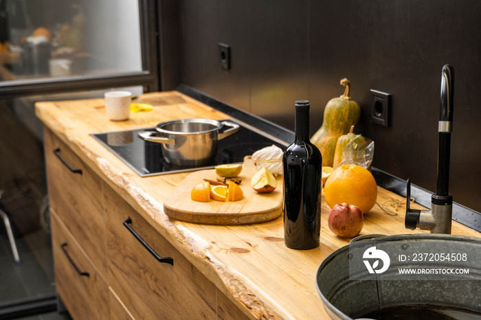 Oak kitchen worktop on kitchen with a sink, cookstove and food ingredients, bottle and kitchen facil