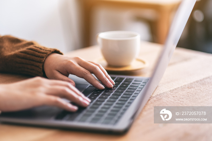 Closeup image of womans hands using and typing on laptop computer keyboard