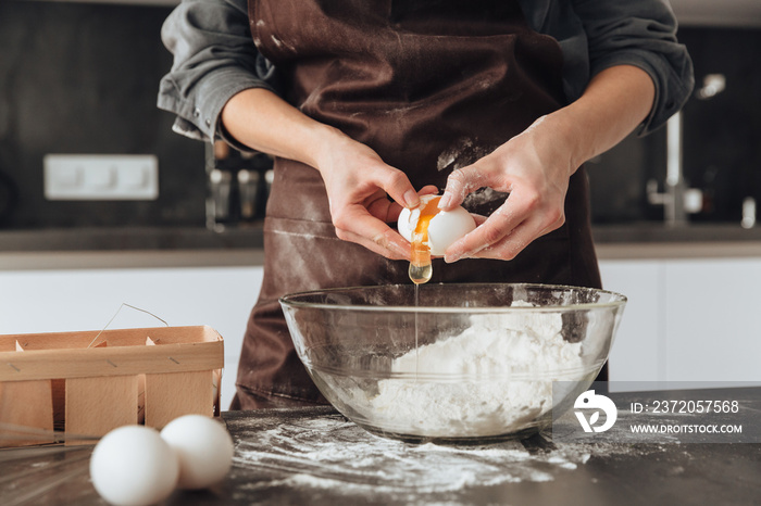 Cropped image of young woman cooking the dough.