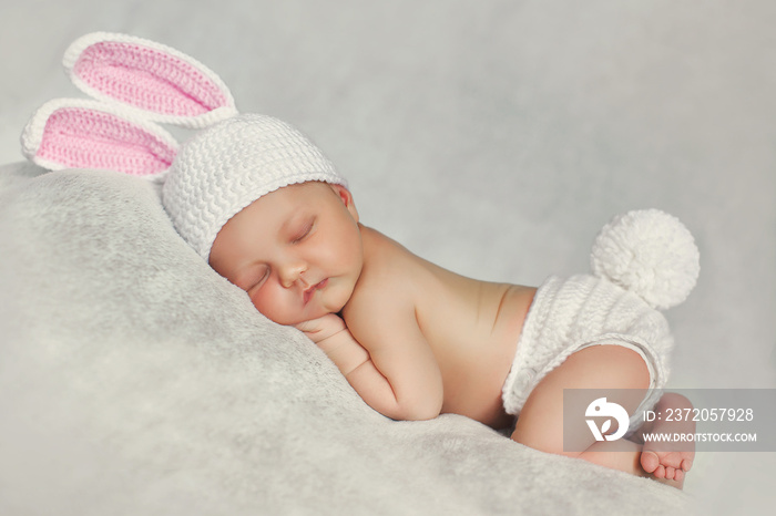 Peaceful sleep of a newborn baby in the grey beds,cute baby in hat with Bunny ears, sleeping sweetly