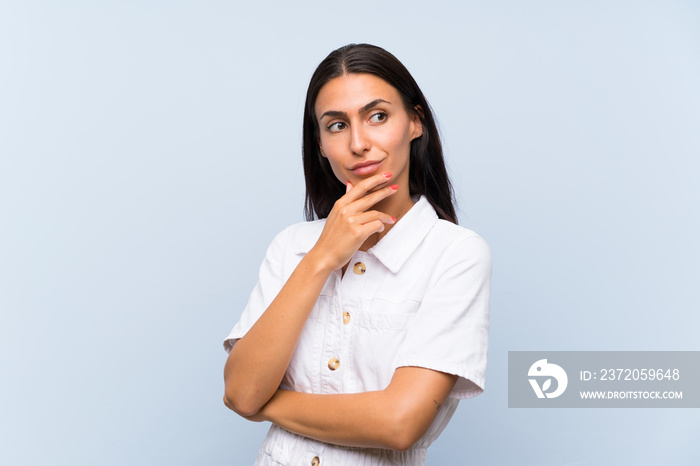 Young woman over isolated blue background thinking an idea