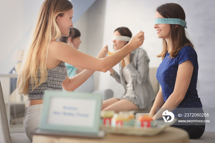 Women taking part in game at baby shower party