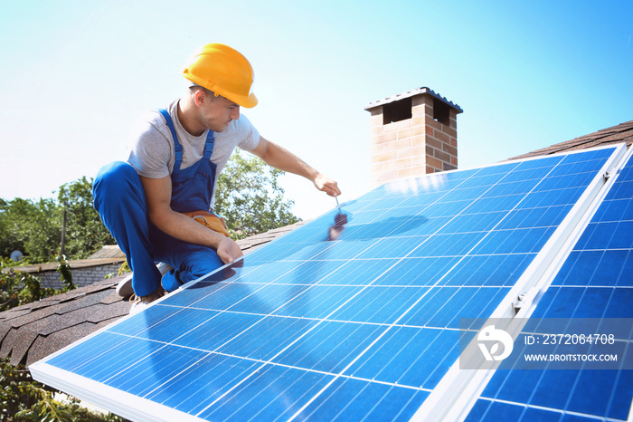 Worker installing solar panels outdoors