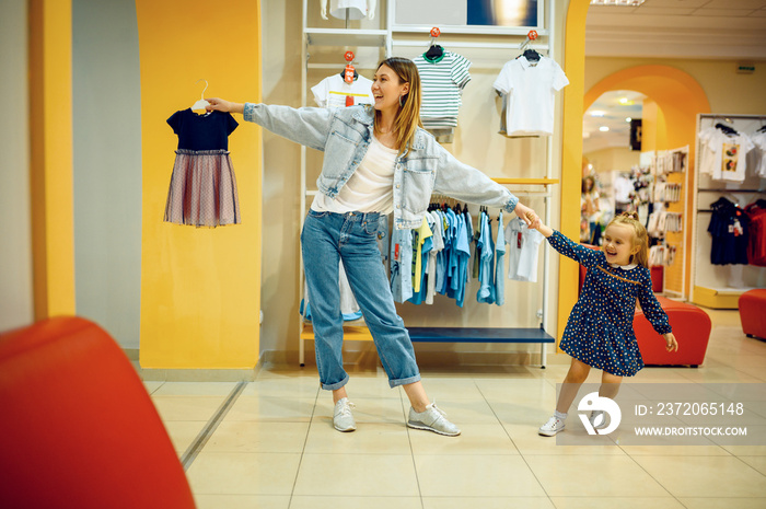 Mother and little baby choosing clothes in store