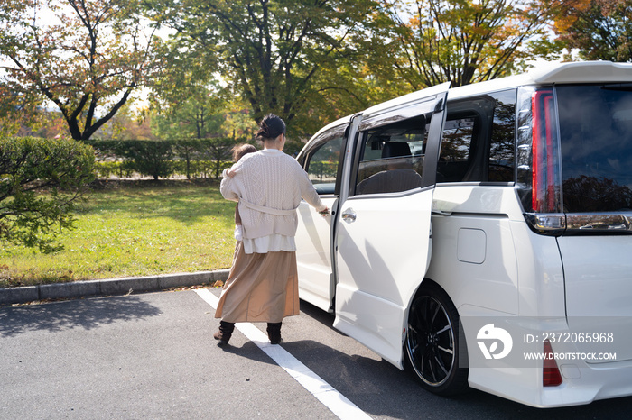 スライドドアの車に乗る主婦