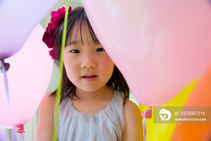 Girl with birthday party balloons, portrait