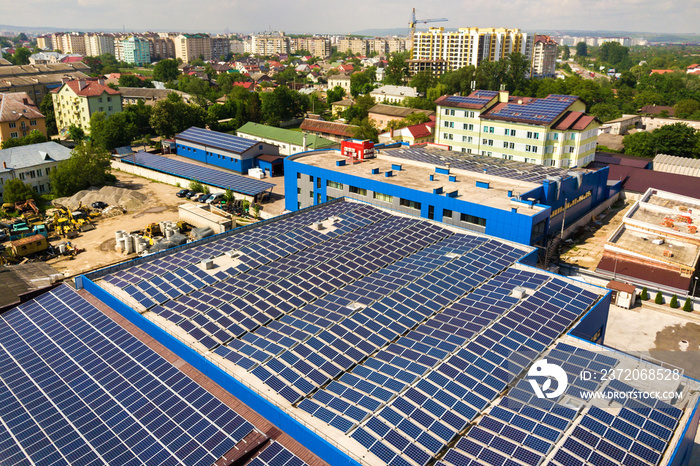 安装在工业建筑屋顶上的许多光伏太阳能电池板的鸟瞰图。